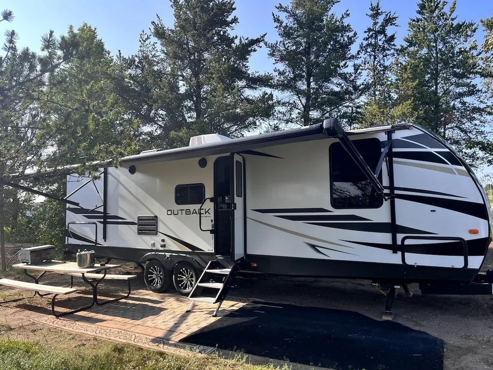 Grant Haven Suite rental camper with awning and picnic table