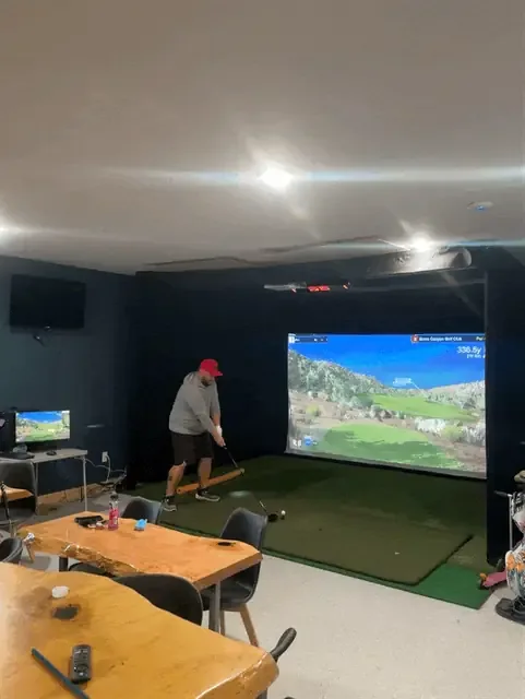 Seating and the indoor golf simulator at Grant Haven Campground